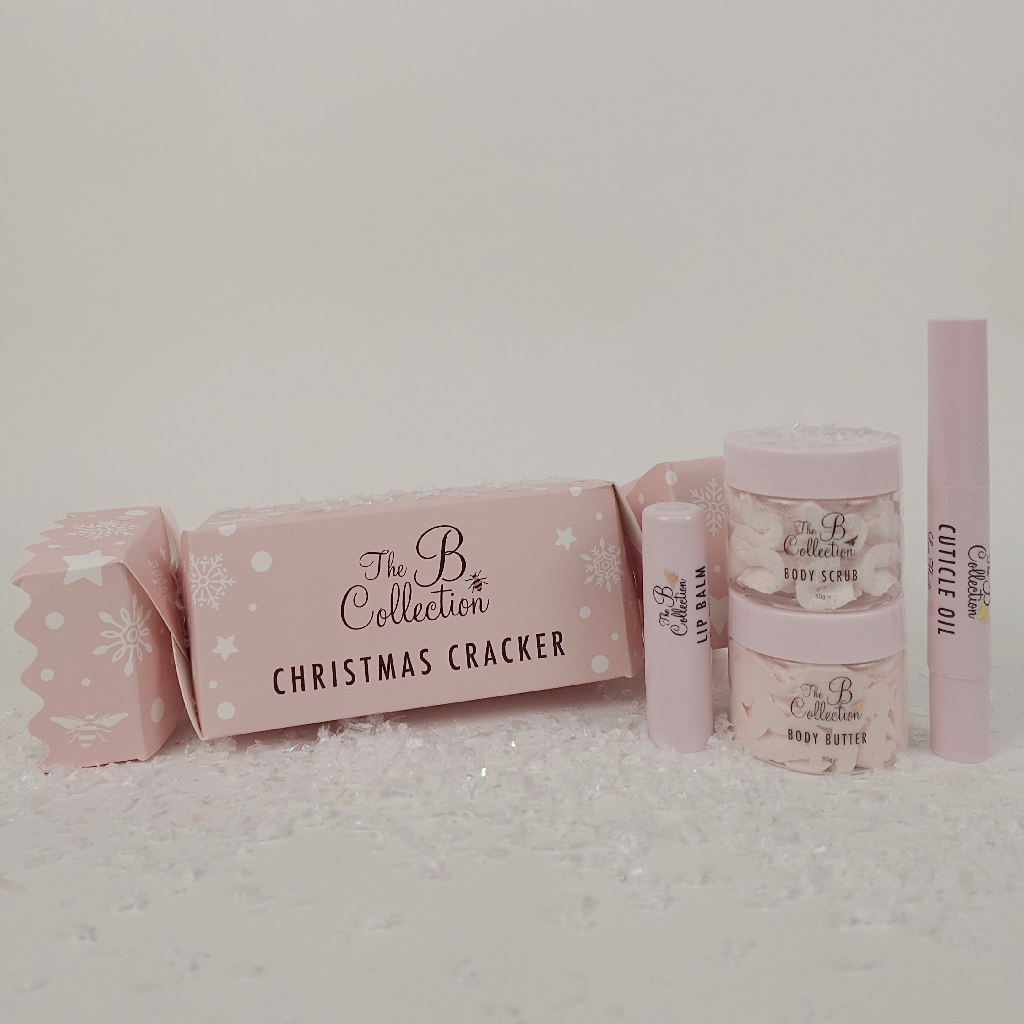 Pink Christmas cracker with 'The B Collection' branding on a light gray background